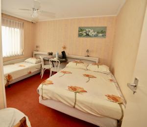 a bedroom with two beds and a desk with a computer at Kuipers Bed in Volendam