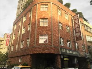 a red brick building with a sign on it at Rich Zone Hotel in Taipei