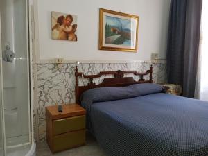 ローマにあるAlbergo Stadlerのベッドルーム1室(ベッド1台付)が備わります。壁に絵が飾られています。