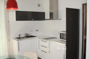a white kitchen with a sink and a microwave at Appartamento "Corte Ceci" in Lucca