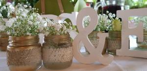 three mason jars filled with flowers on a table at Casale Valle Agnese in Godrano +129 photos