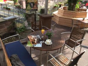 einen Holztisch und Stühle auf einer Terrasse in der Unterkunft Badischer Hof in Bühl