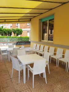 a row of tables and chairs on a patio at Hotel Margot in Lido di Camaiore