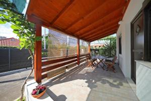 a patio with a wooden roof with a table and chairs at Apartments Krolo in Zadar