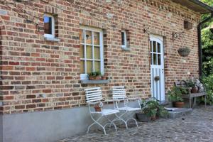 two chairs sitting outside of a brick building at De Volle Maan - Zomerhuis in Sint-Lievens-Houtem