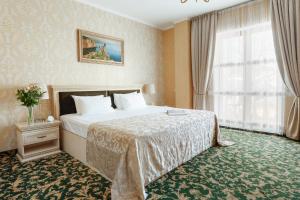 a hotel room with a large bed and a large window at Boutique Hotel California in Odesa