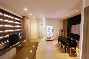 a living room with a dining table and a television at D.Y. Hotel in Taichung