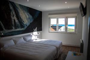Un dormitorio con una cama grande y una ventana. en Hospedium Morada da Moa, en O Pindo