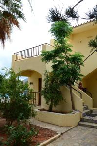 a house with a tree in front of it at Alex Home Apartments in Hersonissos