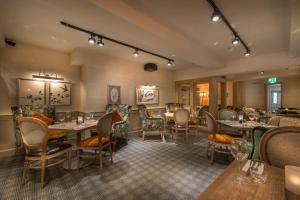 a restaurant with tables and chairs in a room at The Three Swans Hotel, Hungerford, Berkshire in Hungerford