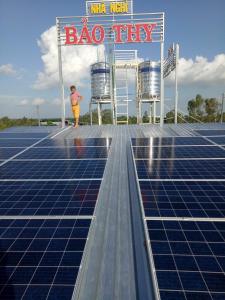 a woman standing on top of a solar array at Bao Thy Hotel in Chau Doc