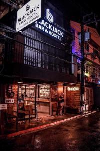 un panneau indiquant un restaurant dans une rue la nuit dans l'établissement Blackjack Bar and Hostel, à Chaweng