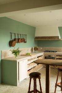 a kitchen with a table and some pots and pans at La Clairière de la reine Hortense - Pierres d'Histoire in Saint-Prix