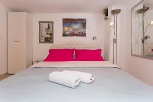 a bedroom with a large bed with red pillows at Studio Varos in Split