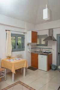 a kitchen with a table and a sink and a stove at Ta Spitakia Tsarbopoulos in Kyparissia