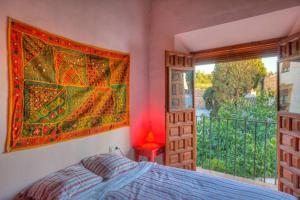 グラナダにあるBreathtaking Alhambra view balconies, Albaizynのベッドルーム1室(ベッド1台付)が備わります。壁には大きな絵画が飾られています。