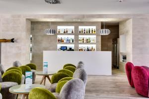 a lobby with chairs and tables and a bar at Barceló Teguise Beach - Adults Only in Costa Teguise