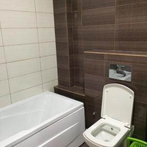 a bathroom with a white toilet and a bath tub at Seawave Beach in Constanţa