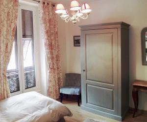 a bedroom with a bed and a chandelier at Hotel La Regence in Villefranche-sur-Mer