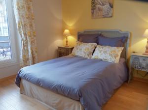 a bedroom with a bed with blue sheets and pillows at Hotel La Regence in Villefranche-sur-Mer