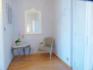a chair and a table in a room with a mirror at Hotel La Regence in Villefranche-sur-Mer
