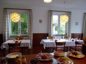 a dining room with two tables and two windows at Lindenzimmer Stöcken in Oetzen