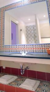 a bathroom with a sink and a mirror at Hotel La Regence in Villefranche-sur-Mer