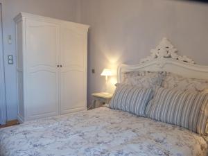 a bedroom with a white bed with a white cabinet at Hotel La Regence in Villefranche-sur-Mer