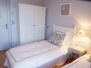 a white bedroom with a bed and a night stand at Hotel La Regence in Villefranche-sur-Mer