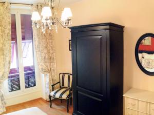 a large black cabinet in a room with a chair at Hotel La Regence in Villefranche-sur-Mer