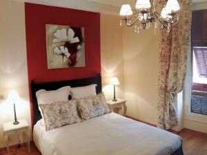 a bedroom with a white bed with a red wall at Hotel La Regence in Villefranche-sur-Mer