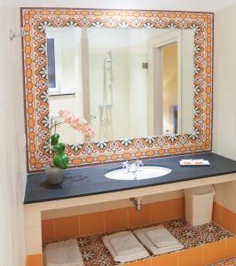 a bathroom with a sink and a mirror at Hotel La Regence in Villefranche-sur-Mer