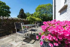 a patio with a table and chairs and pink flowers at Windermere Suites in Windermere