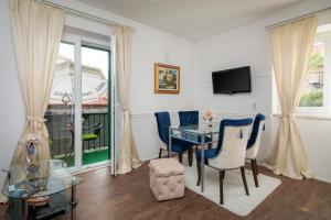 a dining room with a table and chairs and a tv at Apartment Helena in Split