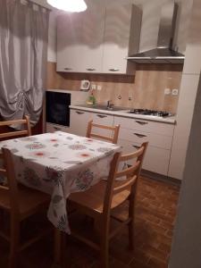 a kitchen with a table and chairs and a kitchen with white cabinets at Apartmani Branko Vojnovic in Omiš