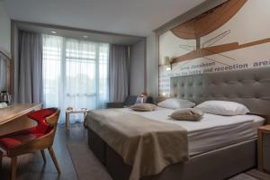 um quarto de hotel com uma cama grande e uma secretária em Effect Grand Victoria Hotel - Ultra All Inclusive em Sunny Beach