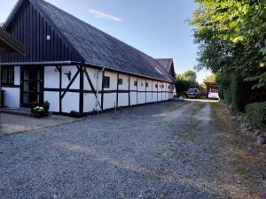 un granero blanco con techo negro y entrada en Dåstrup Bed & Breakfast, en Viby