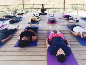 a group of people laying on mats in a yoga class at Vida Pura Apartments in Odeceixe