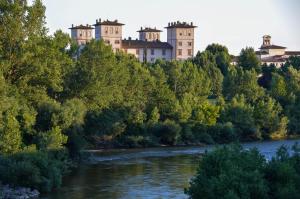 a castle on top of a hill next to a river at Sweet Emily B&B in Montelupo Fiorentino