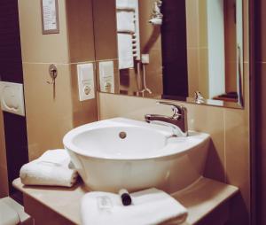 a bathroom with a sink and a mirror and towels at Landhotel-Neunburg in Neunburg vorm Wald