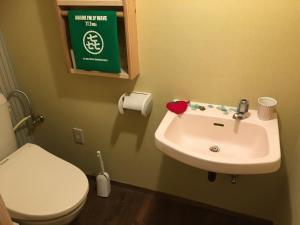 a bathroom with a white sink and a toilet at Guest house AmaMin in Amami