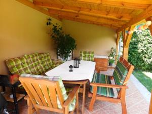 a dining table and chairs on a patio at Bodzavirág Apartman in Hegykő