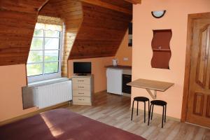 a bedroom with a desk and a table with two stools at Apartamentai Vanagupės rajone in Palanga