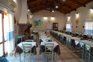 una grande stanza con tavoli e sedie di Agriturismo Agrifoglio a San Giovanni Suèrgiu