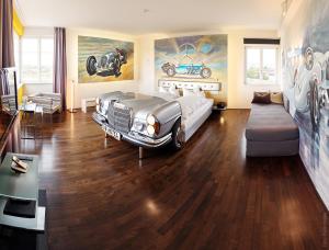 a room with a bed and a car on the wall at V8 HOTEL Classic Motorworld Region Stuttgart in Böblingen