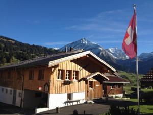 ein Holzgebäude mit einer Flagge davor in der Unterkunft Gässlihof in Gstaad