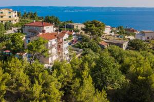 a town on a hill with houses and the water at Katarina apartmani in Podstrana