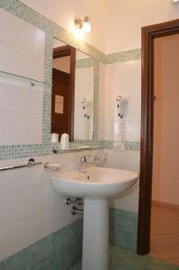 un bagno con lavandino e specchio di Attinia a San Vito lo Capo Altre 41 foto