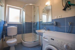 a bathroom with a toilet and a sink and a shower at Katarina apartmani in Podstrana +40 photos