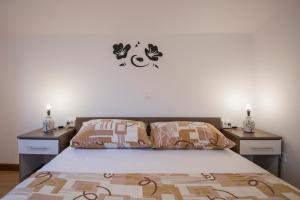 a bedroom with a bed with two night stands and two lights at Katarina apartmani in Podstrana
